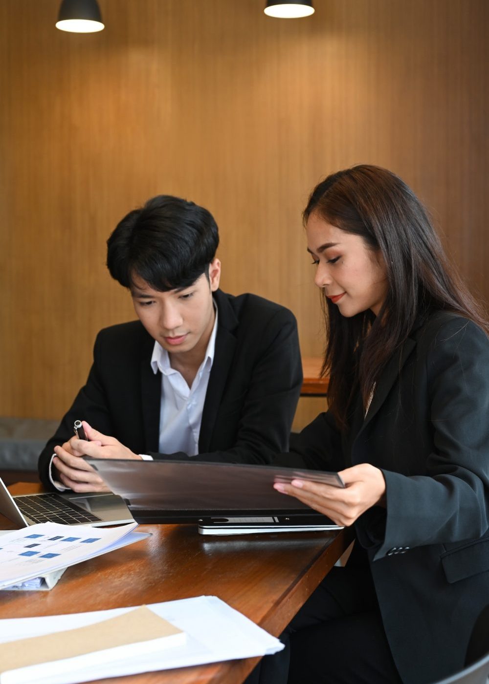 Two parties engaged in a mediation session with a mediator facilitating the discussion in a calm office environment.